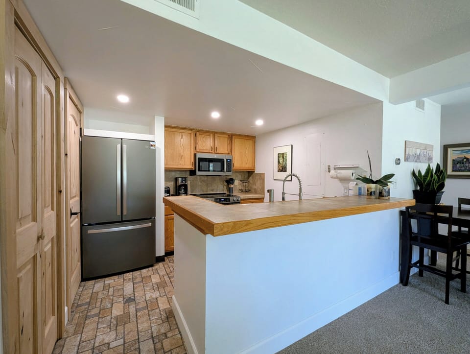 Your fully equipped kitchen features stainless steel appliances and a spacious breakfast bar where you can enjoy morning coffee or casual meals.