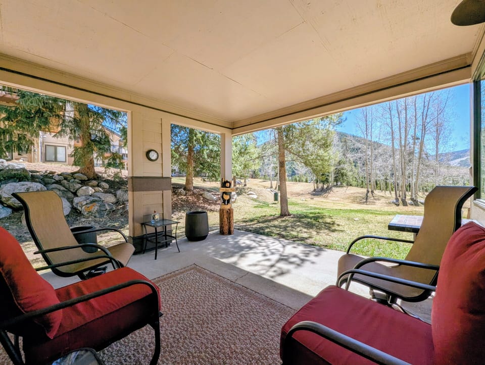 Relax in your private screened patio with mountain views, perfect for morning coffee or evening conversations in comfortable outdoor seating.