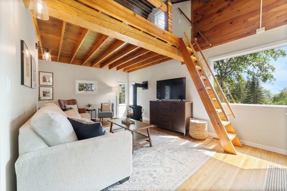 The cozy living room offers a gas stove fireplace, TV, extra blankets, games and a sleeper sofa