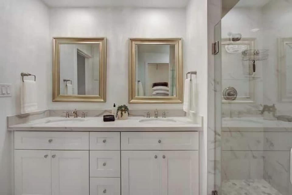 Bright white bathroom with a dual-sink vanity and ample storage