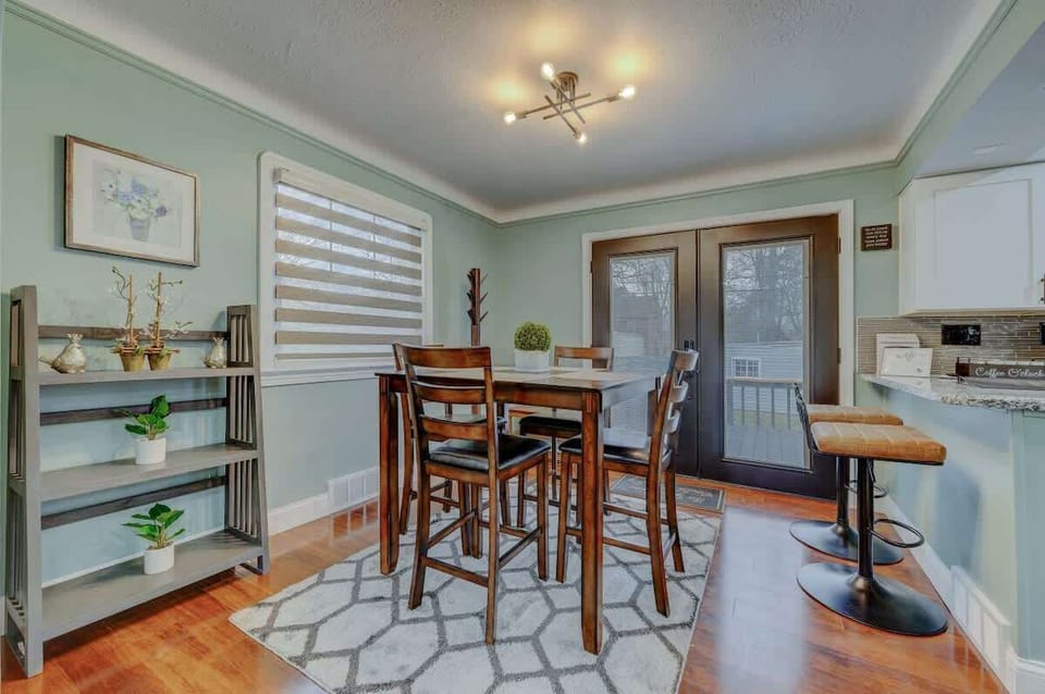 Dining nook w/ stylish lighting, wood table & built-in shelving for decor