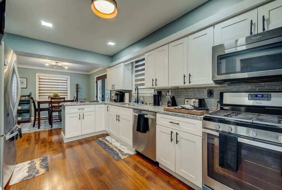 Spacious kitchen w/ white cabinetry, modern appliances & plenty of prep space