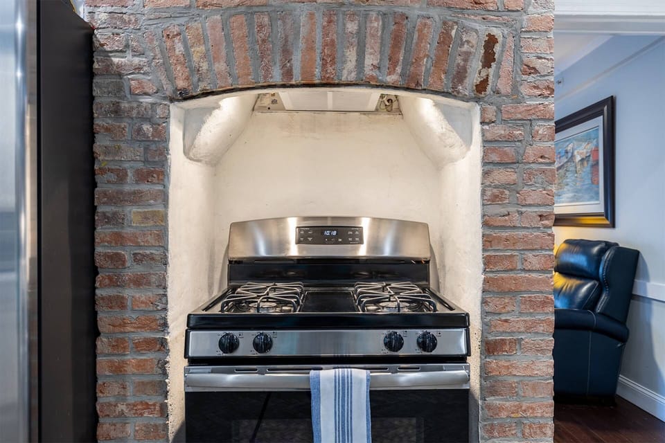The cleverly designed kitchen makes use of the historic original fireplace to house the stainless steel range.