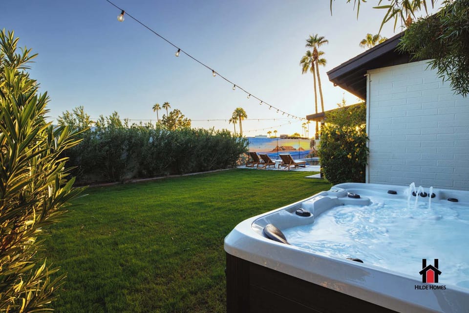 Indulge in the bubbling hot tub under festive string lights in your private yard.