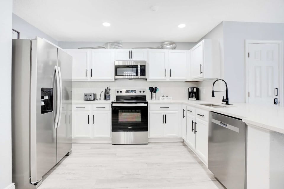 Modern kitchen with stainless steel appliances and white cabinetry for a clean look
