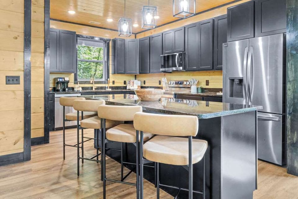 The modern kitchen is a chef’s dream, equipped with high-end stainless steel appliances and sleek black cabinetry.