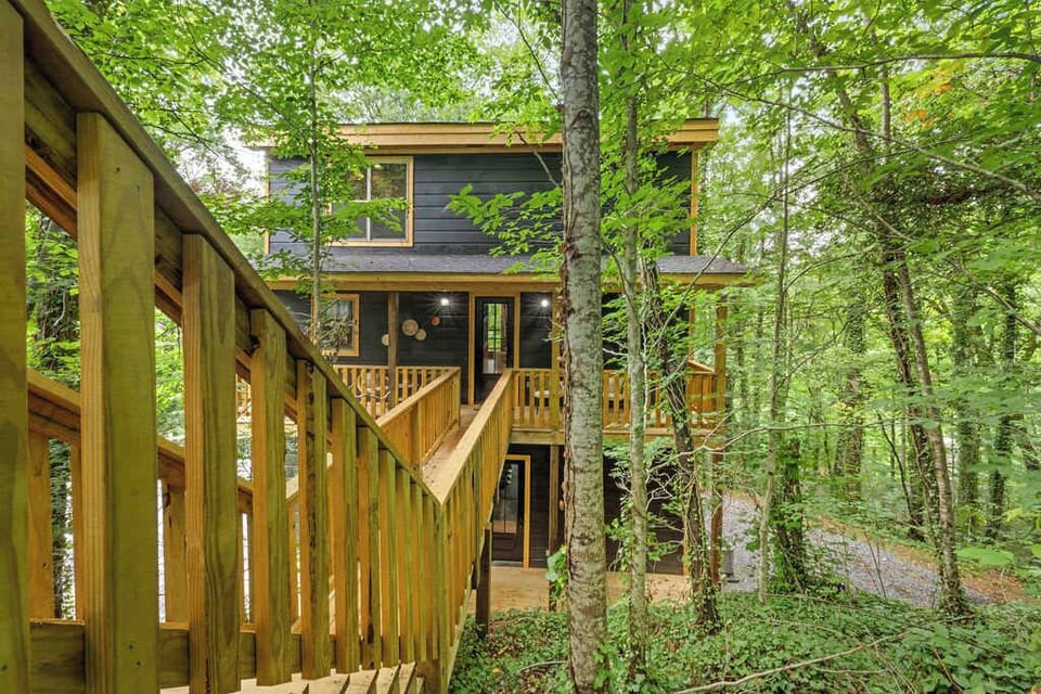 As you approach the property, a well-crafted wooden stairway leads you to the welcoming entrance. This charming ascent is surrounded by the lush greenery of the forest, creating a serene and inviting approach to the home.