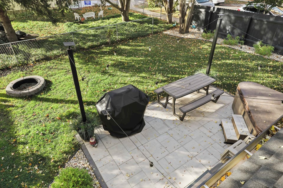 Backyard featuring a 12x18 patio, gas grill, picnic table, bistro chairs, and fire pit/chairs. The hot tub you see in the right corner is NOT available or on site for use.
