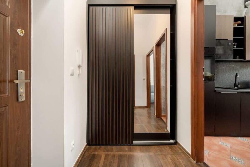A stylish hallway leads into the main living area, with modern wooden paneling and a welcoming, contemporary design.