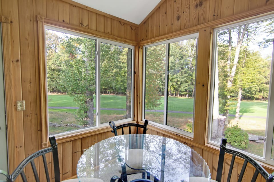 Sunroom with a bar table, cozy lounge chairs, reading area and board games.
