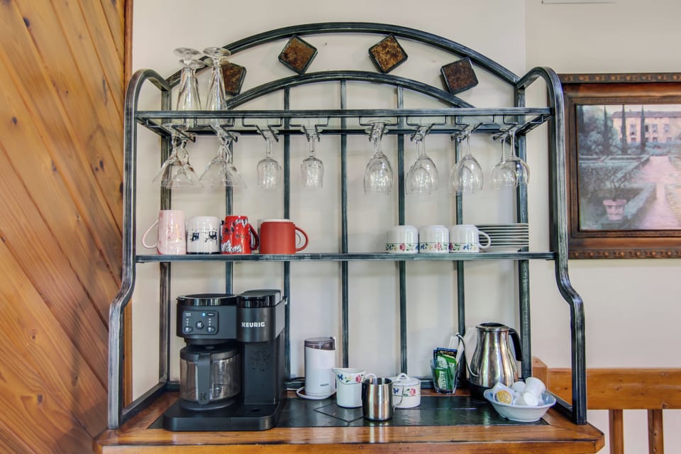Cozy coffee bar with Keurig, mugs and glassware for a perfect morning brew.