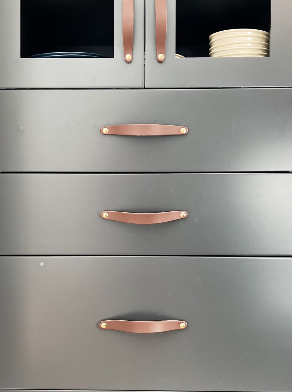 Leather handle details on kitchen cabinets.
