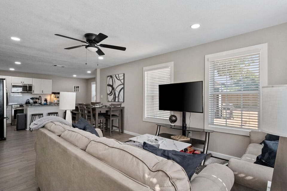 View of living room spaces into kitchen and dining area from side entry door