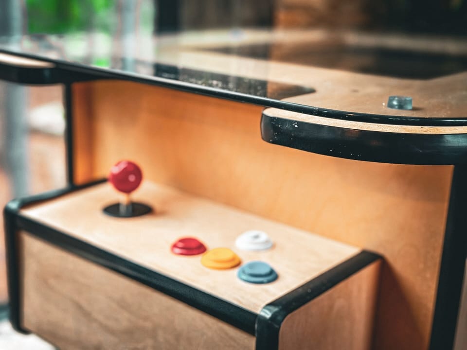 The entertainment loft is packed with excitement, featuring a pool table, shuffleboard, and arcade games. Perfect for family game nights or friendly competitions! | Timberline, Broken Bow, Oklahoma | Voyax Luxury Vacation Rentals