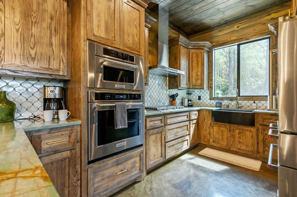 The spacious kitchen is fully equipped and perfect for whipping up delicious meals together! Enjoy plenty of counter space and modern appliances, making cooking a breeze! | Timberline, Broken Bow, Oklahoma | Voyax Luxury Vacation Rentals