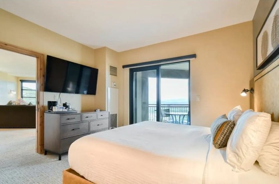 Inviting bedroom with a plush bed and private balcony entrance.