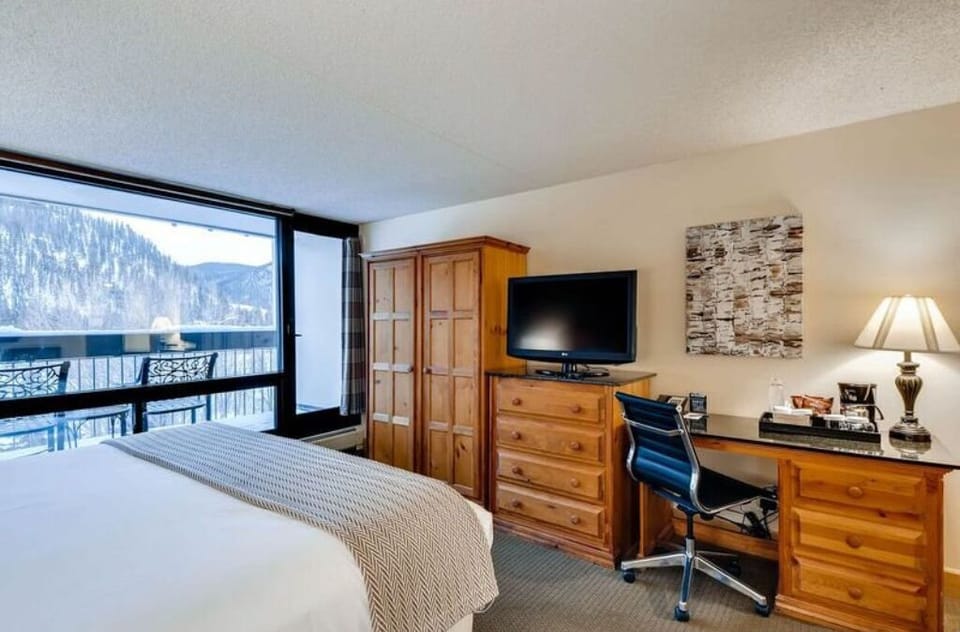 Elegant bedroom with workspace and breathtaking outdoor scenery.