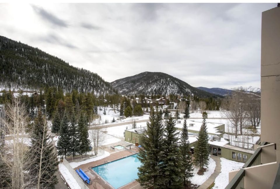 Scenic balcony view featuring a pool and majestic mountains.