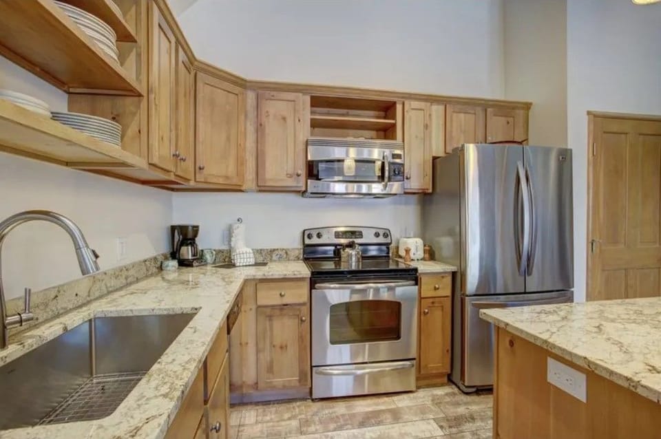 Modern kitchen with stainless steel appliances and wood cabinetry.