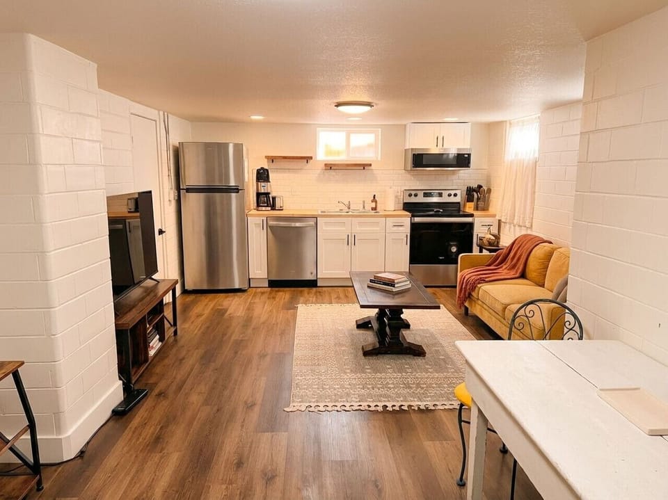 Cozy living area with smart TV, full kitchen with stainless steel appliances, and dining space -- perfect for relaxing in Denver`s Highlands neighborhood
