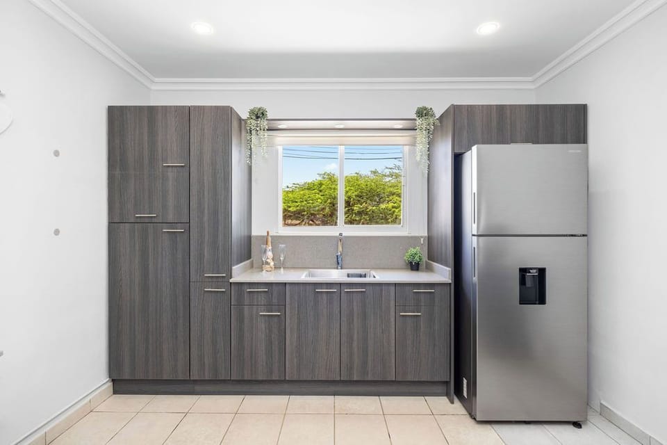 This kitchen boasts ample cabinets for all your essentials and a spacious fridge, making meal prep and storage a breeze. Your cooking adventures await!