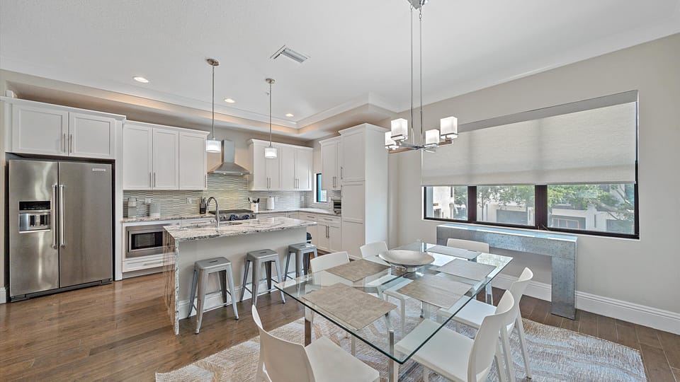 Bright and modern kitchen with stainless steel appliances and a spacious dining area, perfect for sharing meals after a day at Sarasota’s beaches.