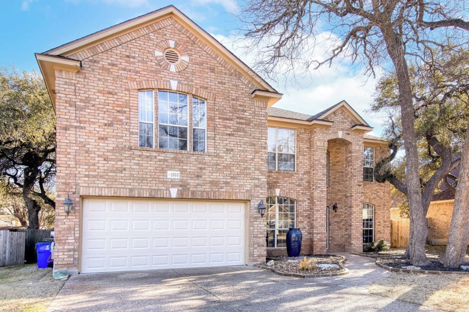 The exterior showcases a simple and modern brick design, offering a clean, timeless aesthetic. A garage at the front adds convenience and functionality to this charming house.