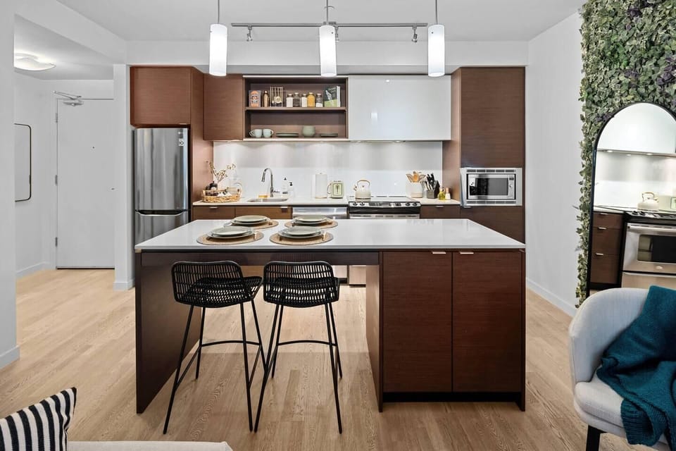 Kitchen prep area featuring a multi-functional island with overhang counter seating for two.