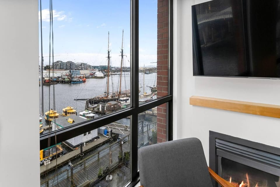 Direct window view of the active working harbor, passing boats, and the historic bridge walkway.