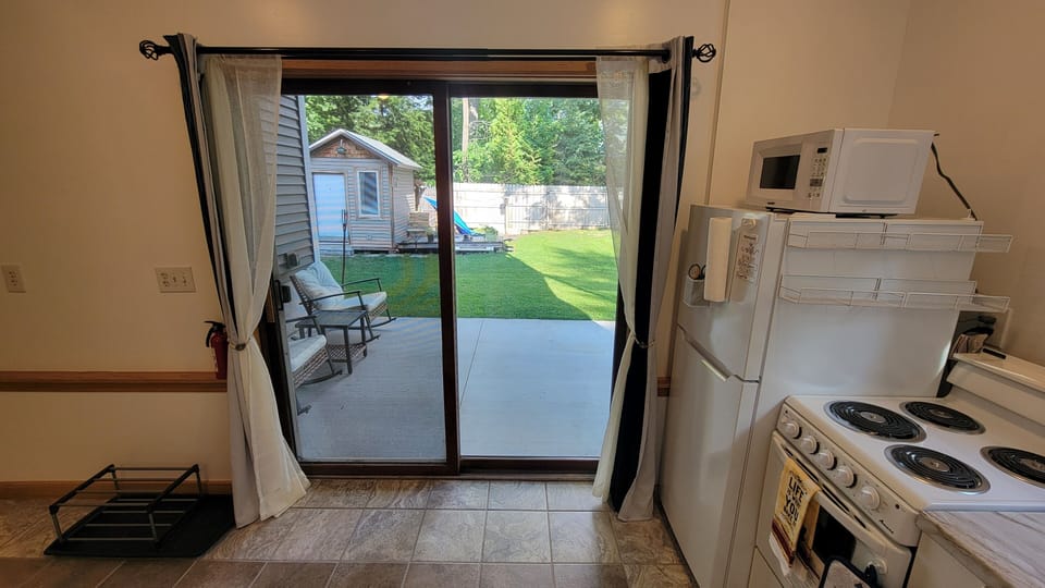 inside the apartment, facing out at patio and back yard
