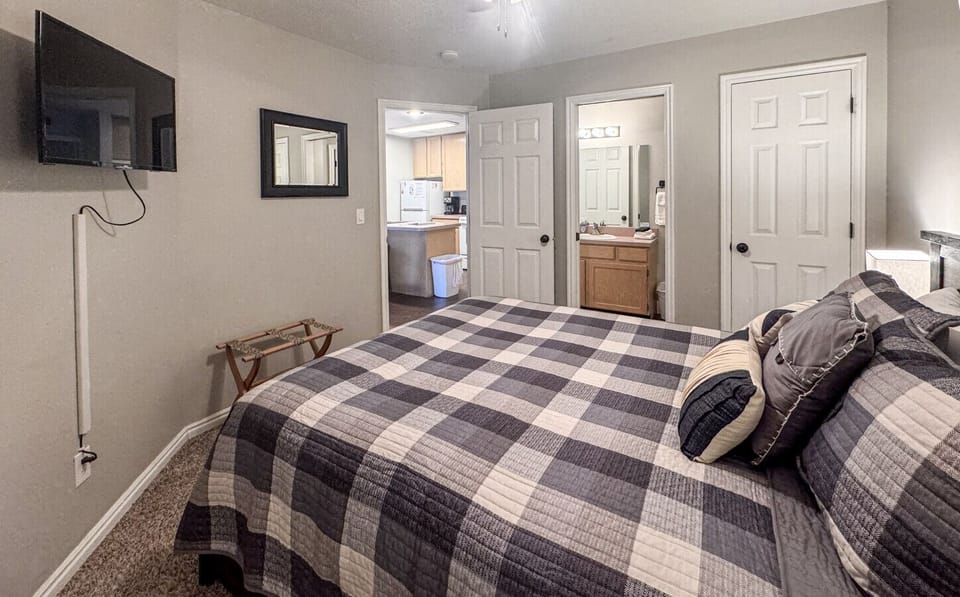 Spacious bedroom with ensuite bathroom and kitchen access, ideal for comfort and convenience