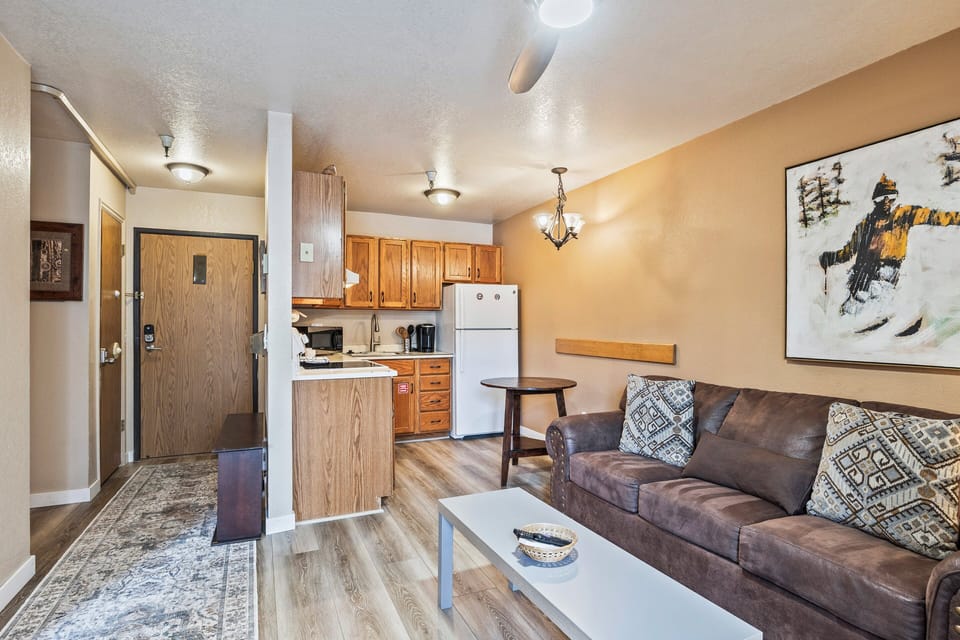 Cozy living space featuring a comfortable sofa, dining nook, and kitchen—perfect for relaxing after a day out.