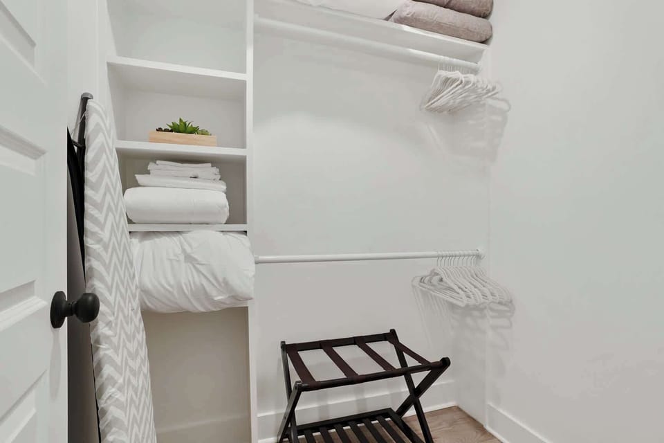 Primary Closet is Spacious & Equipped with a Luggage Rack and Extra Bedding