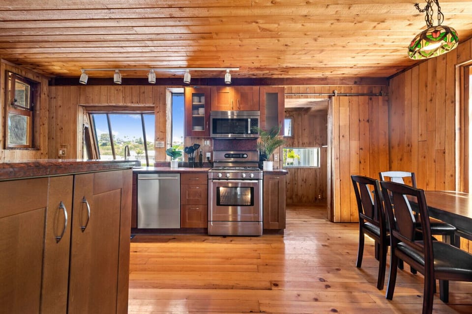 Create delicious meals in this modern kitchen with rustic charm. The stainless steel appliances, including a dishwasher, gas burner, oven, and microwave, provide everything you need. Wooden cabinets add a touch of warmth.