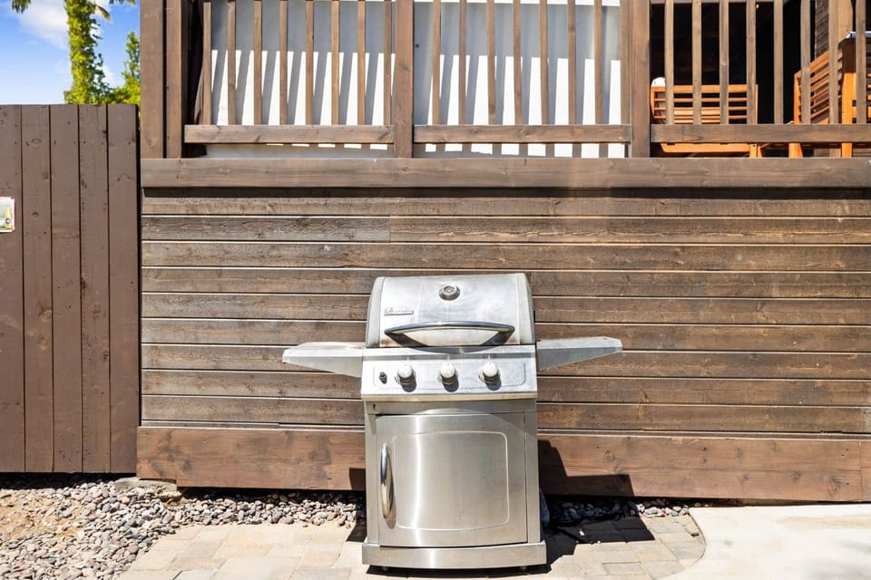 Stainless steel grill tucked against the deck for easy outdoor cooking.