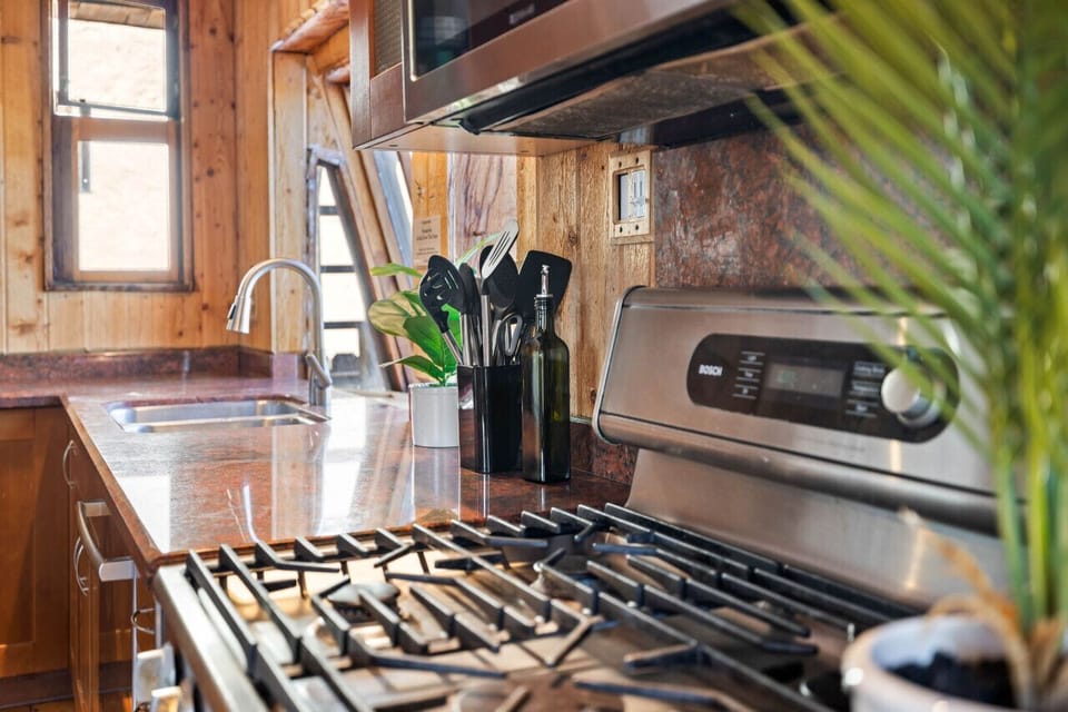 Create delicious meals in this modern kitchen with rustic charm. The stainless steel appliances, including a dishwasher, gas burner, oven, and microwave, provide everything you need. Wooden cabinets add a touch of warmth.