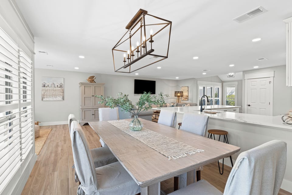 In the dining area, there are 6 chairs and extra seating at the kitchen island.