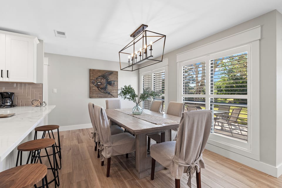 In the dining area, there are 6 chairs and extra seating at the kitchen island.