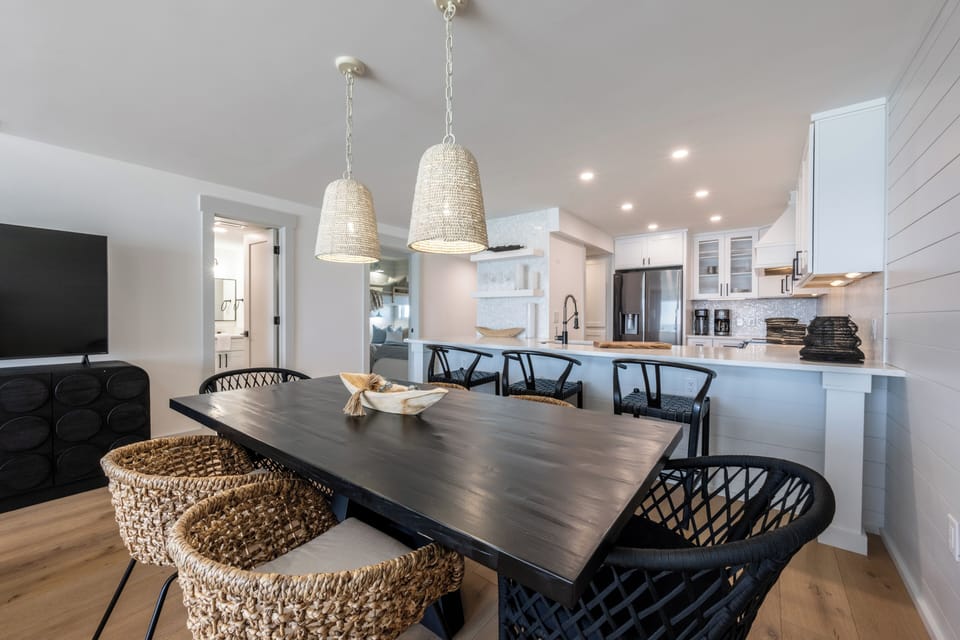 The dining table have six chairs and three stools at the breakfast bar.