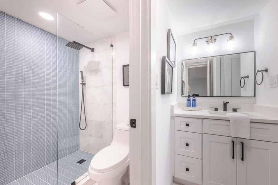 The bunk room's shared en-suite bathroom features a walk-in shower and direct access to the hallway.