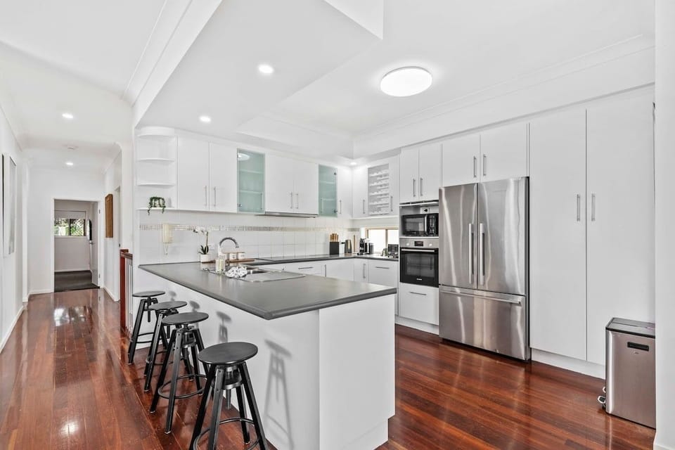 Gourmet kitchen with induction cooktop, oven, microwave, fridge-freezer.