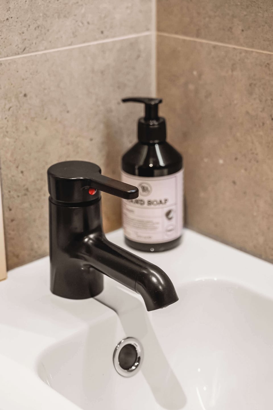 Modern basin with stylish black tap and natural stone detail