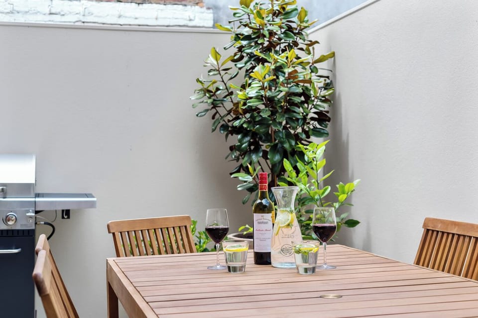 COURTYARD: The sunny courtyard has an outdoor table setting  and barbeque that is perfect for relaxing or entertaining.