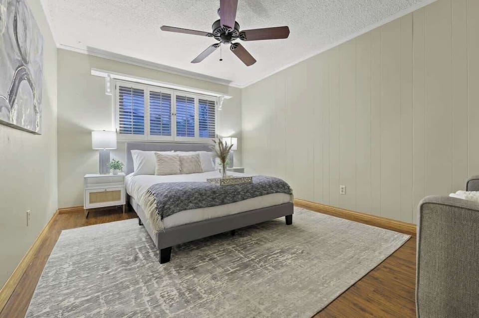 Enjoy the comfort of a queen bed surrounded by soft, neutral tones and gentle bedside lighting, creating a cozy and inviting atmosphere for ultimate relaxation.