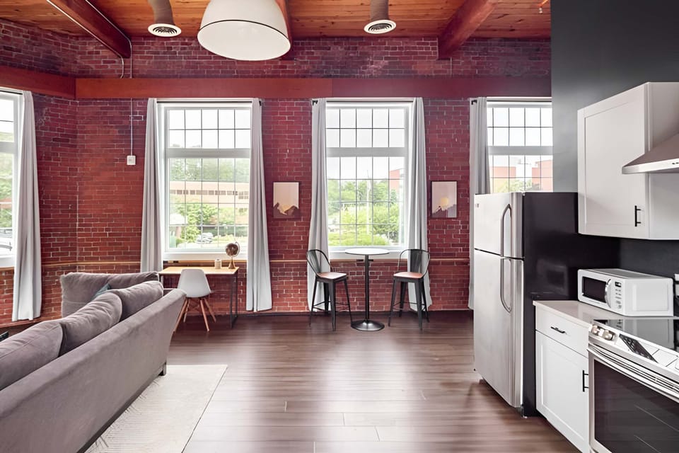 Seating for dining and a desk to work against the brick wall