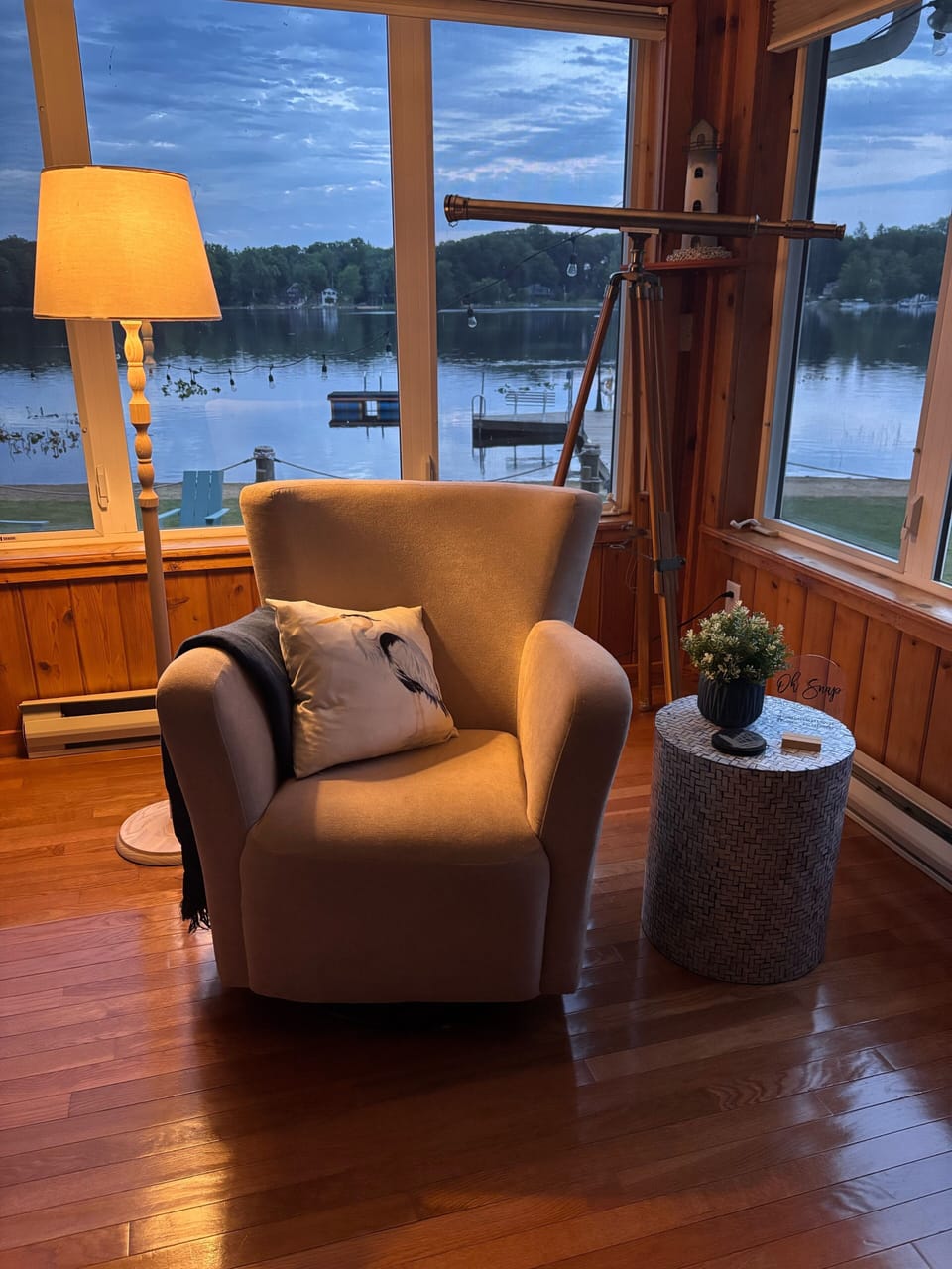 Tucked near the large picture window overlooking the lake, this space features a plush swivel armchair, perfect for curling up with a good book or simply gazing out at the water.
