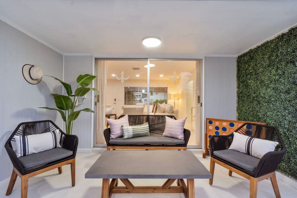 A welcoming patio featuring comfortable seating, a stylish coffee table, and lush greenery for a relaxing outdoor experience.