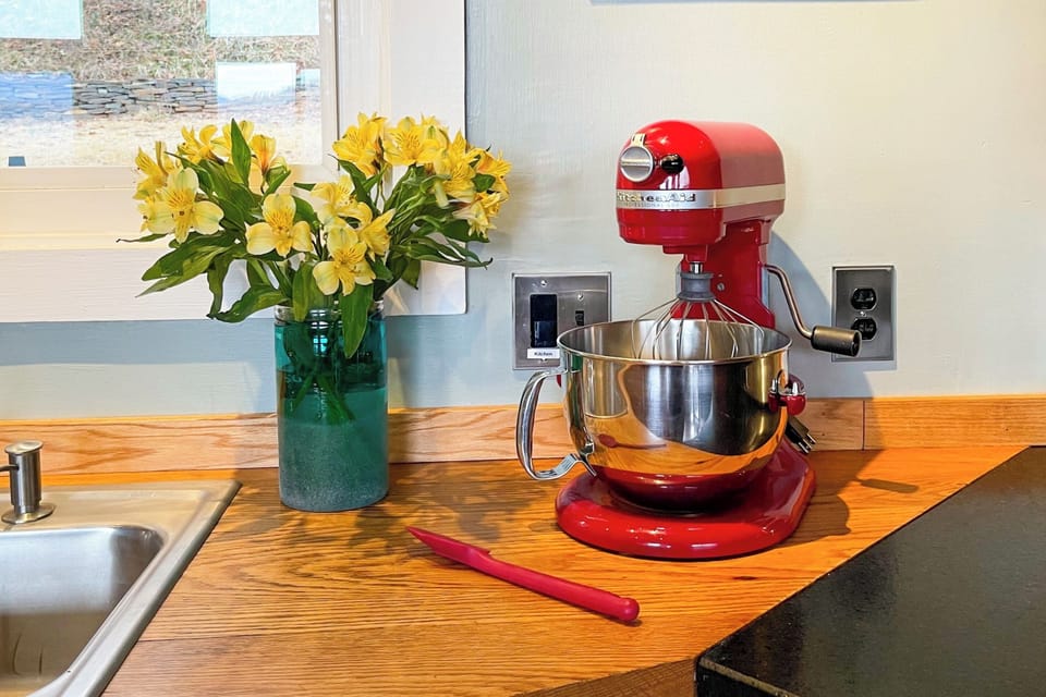 Cheery, well-equipped kitchen with stand mixer—bake with ease and enjoy fresh blooms.