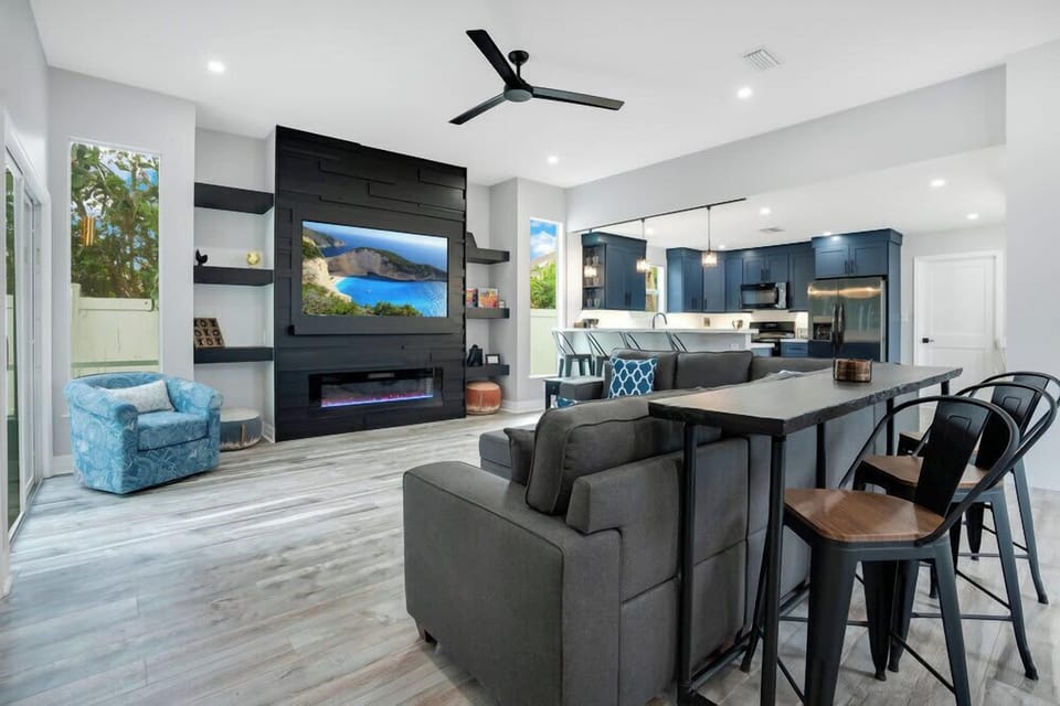 Open-concept living area with a modern fireplace and kitchen featuring navy cabinetry.