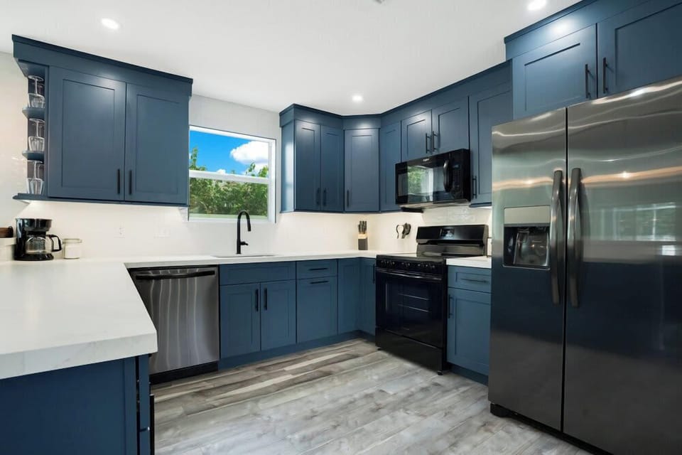 Modern kitchen with blue cabinetry and stainless steel appliances.